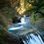 Enchanting autumn scene of Nishizawa Valley with waterfalls, foliage, and serene atmosphere in Japan.