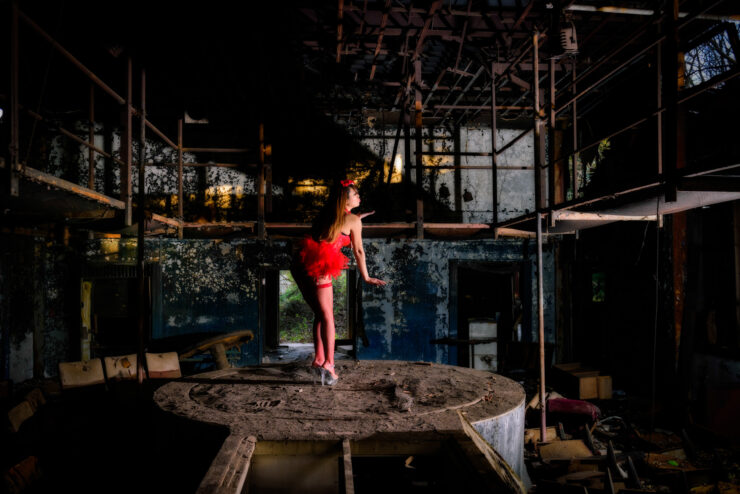 Energy Ritual: Mysterious dancer in red costume channels primal energy in dimly lit space.