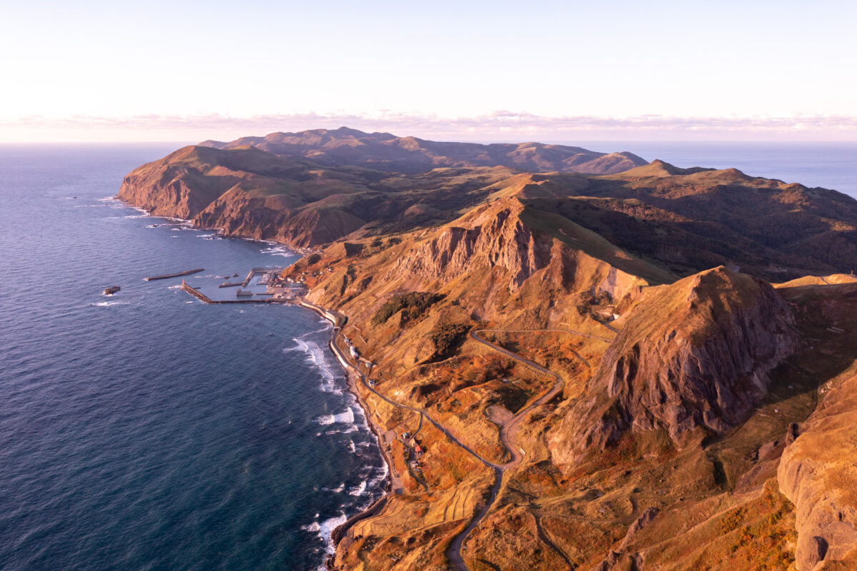 Aerial view of remote beauty: Rebun Islands rugged cliffs and azure waters.