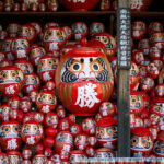 Iconic red Daruma dolls, symbols of perseverance.