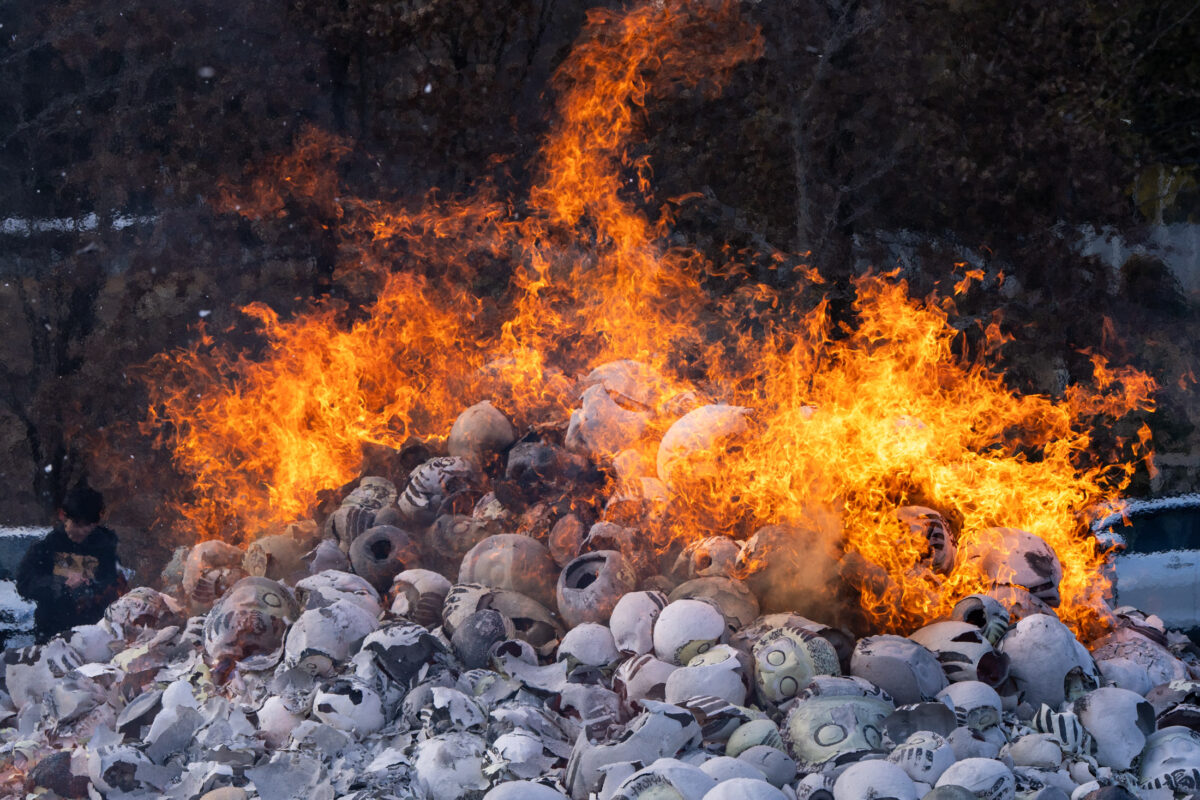 Daruma doll bonfire ritual at Shorinzan Temple, flames rising above snowy temple grounds.