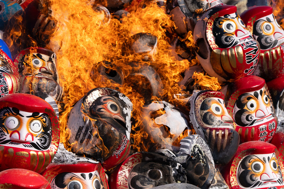 Daruma doll burning ritual at Shorinzan Temple, Japan, flames engulf red dolls