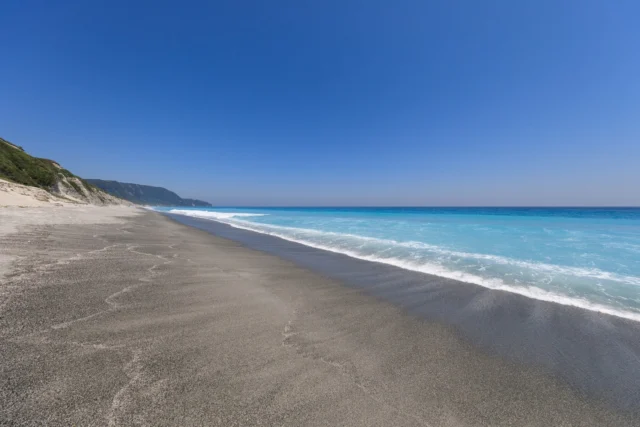 Turquoise waves whisper, Gray sands meet lush green hillside, Sky's vast canopy. ターコイズの波、 緑が丘に灰砂、 空の大広間。 #offbeatjapan #japan #okinawa #hiddenbeauty #pristinebeach #tropicalvibes #islandlife #naturelovers