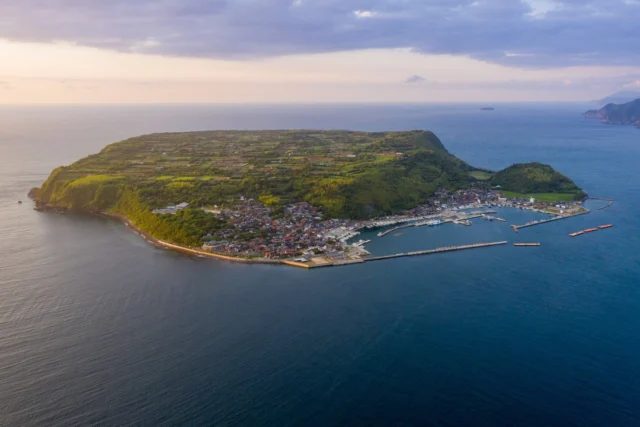 Crescent on the sea, Golden dusk kisses green hills, Quiet harbors dream. 月に抱かれ、 黄金の夕暮れが 緑の丘を吻ぶ。静かな港が夢見る。 #offbeatjapan #japan #coastaltown #ruraljapan #sunsetglow #sustainablepractices #serenity